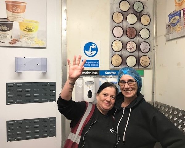 Louise and Dierdre decorating the entrance to the Sweetie Kitchen with some colourful pictures ahead of the ALDI visit 